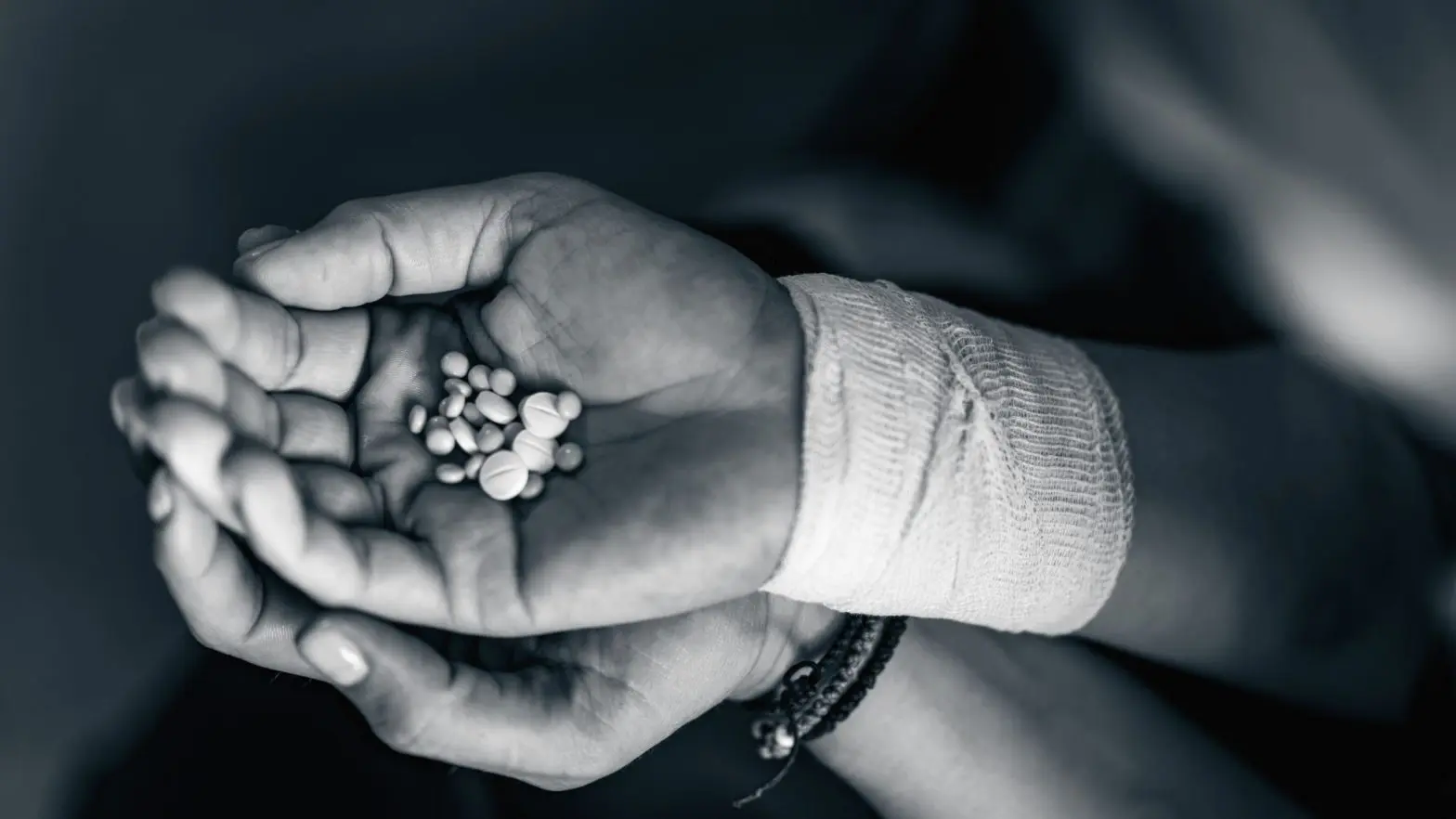 A woman with a hand full of pills suffering from opioid addiction