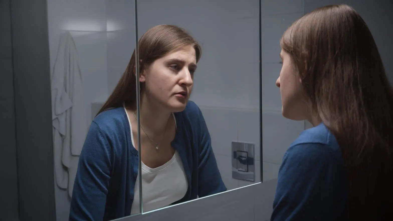 a woman looking at herself in a mirror