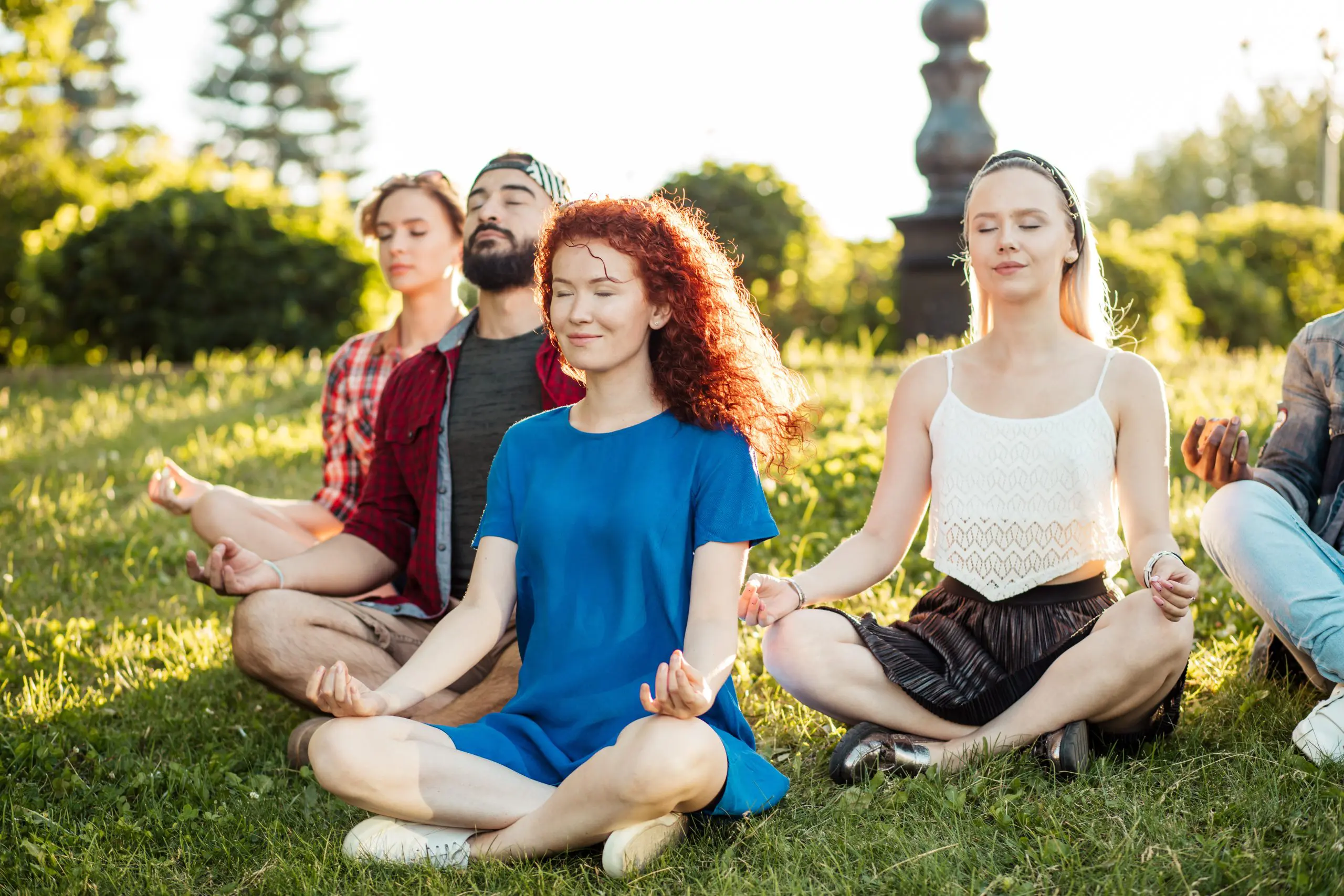 a group of people sitting in the grass