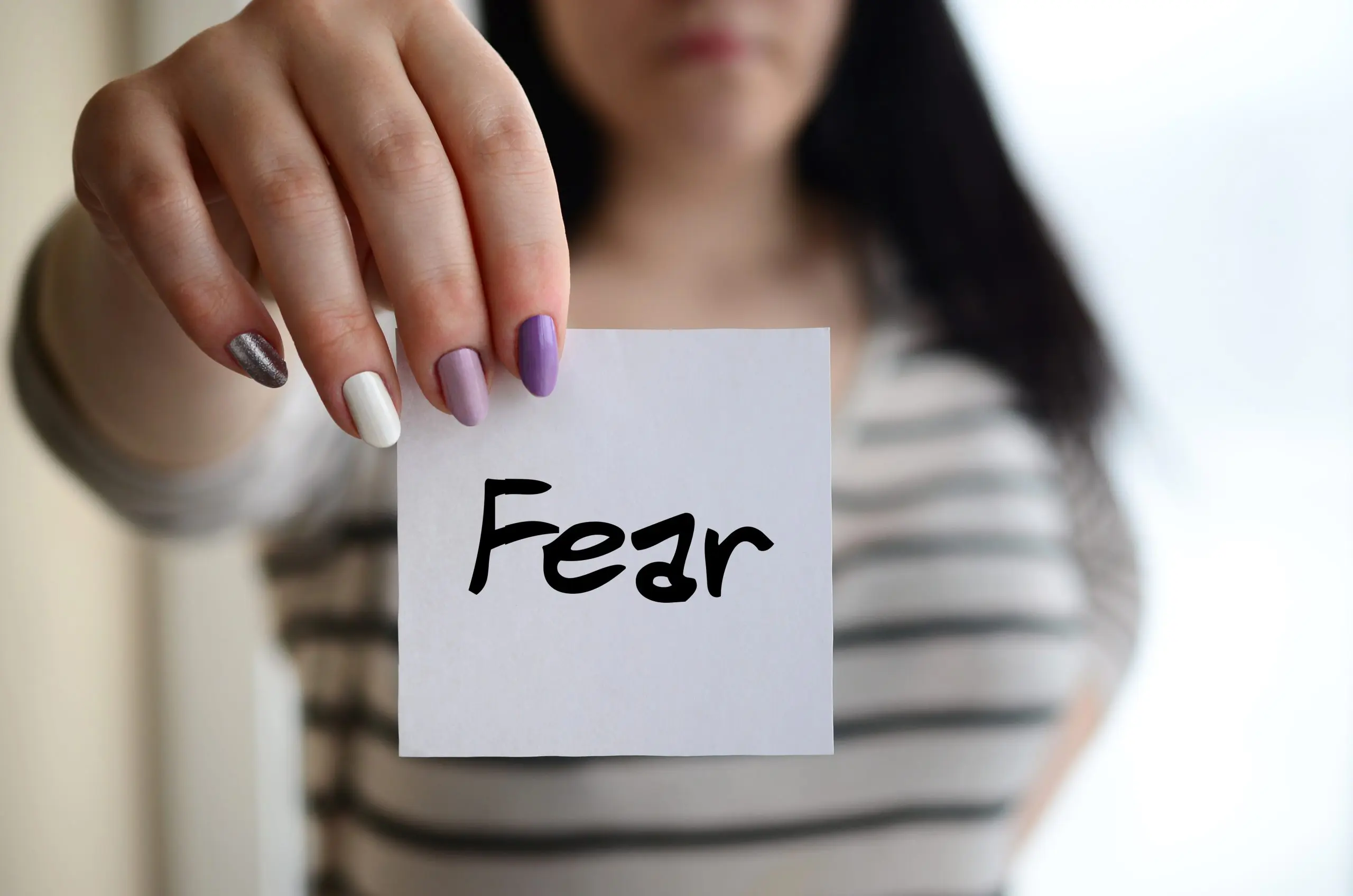 a woman holding a piece of paper with text